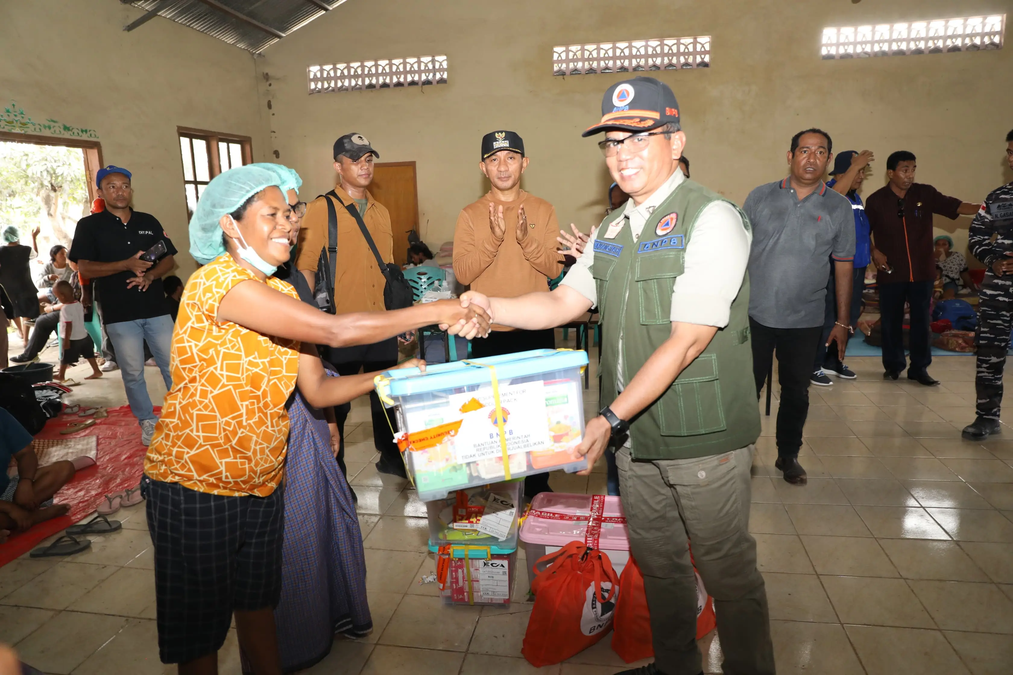 Deputi Bidang Penanganan Darurat BNPB Mayjen TNI Lukmansyah (rompi hijau) saat menyerahkan bantuan kepada warga di pos pengungsian Desa Kringa, Kabupaten Sikka, Nusa Tenggara Timur pada Kamis (7/11).